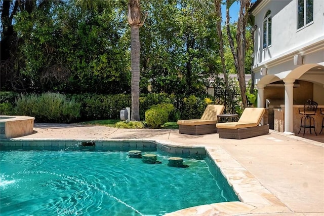view of swimming pool with a patio and an in-ground hot tub
