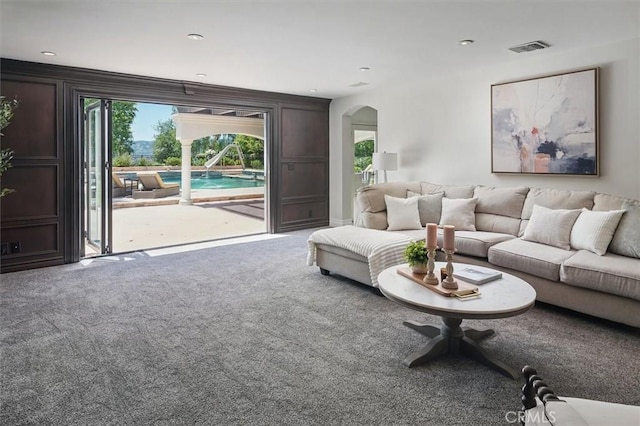 living room featuring carpet, plenty of natural light, arched walkways, and recessed lighting