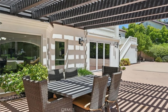 view of patio / terrace featuring outdoor dining area, a pergola, and stairs