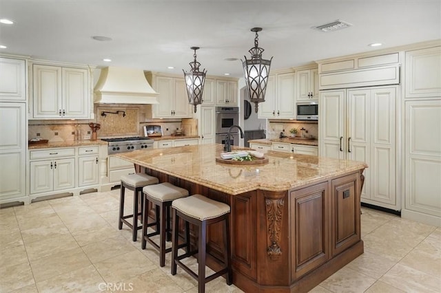 kitchen featuring custom range hood, appliances with stainless steel finishes, cream cabinetry, recessed lighting, and decorative backsplash