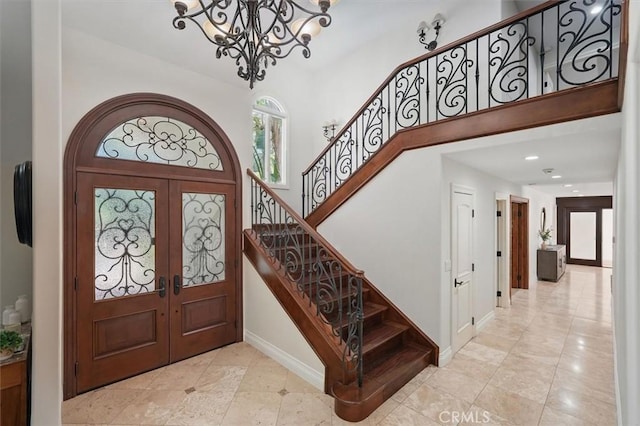 foyer with a chandelier, french doors, stairs, a high ceiling, and tile patterned floors