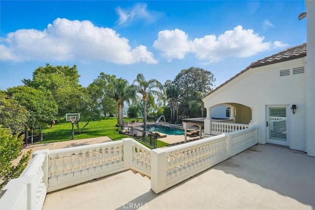 gate featuring an outdoor pool, a patio, and a lawn