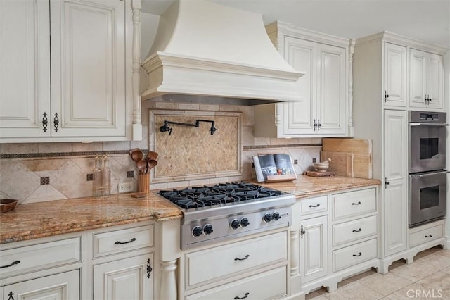 kitchen with custom exhaust hood, appliances with stainless steel finishes, backsplash, and light tile patterned floors