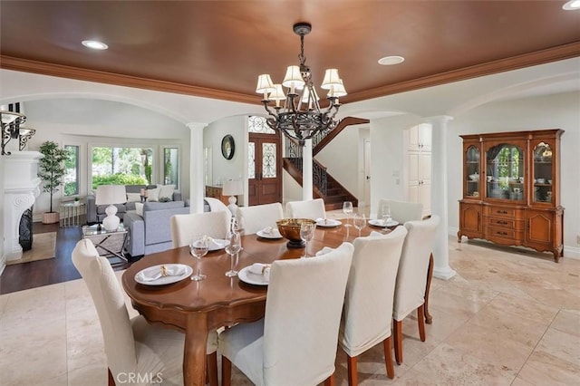 dining room featuring decorative columns, arched walkways, a chandelier, crown molding, and recessed lighting
