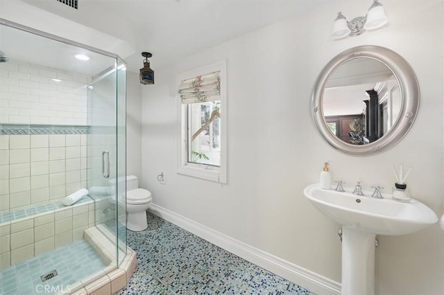 bathroom featuring baseboards, a stall shower, and toilet