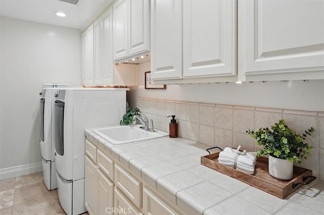 laundry area featuring washer and clothes dryer, cabinet space, baseboards, and recessed lighting