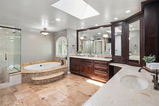 bathroom featuring a shower stall, a garden tub, recessed lighting, two vanities, and a skylight