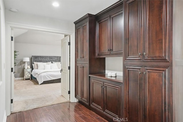corridor with dark wood finished floors, dark carpet, baseboards, and recessed lighting
