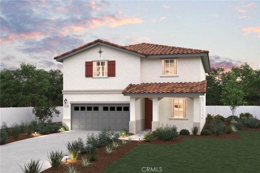 mediterranean / spanish home with a yard, a garage, fence, concrete driveway, and stucco siding