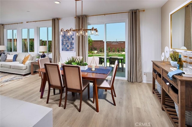 dining area featuring light wood-type flooring and a notable chandelier