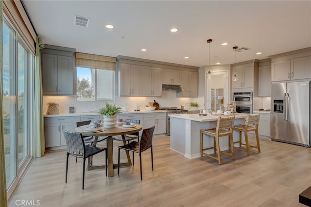 30973 Avenida Ramblas, Highland, CA 92346 - kitchen featuring gray cabinets, tasteful backsplash, light countertops, light wood-style floors, and stainless steel appliances