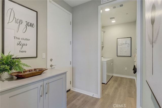 30973 Avenida Ramblas, Highland, CA 92346 - washroom featuring independent washer and dryer, cabinet space, light wood-style flooring, baseboards, and visible vents