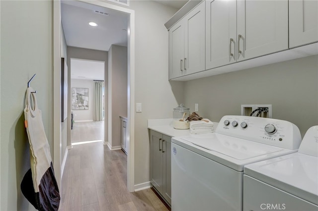 30973 Avenida Ramblas, Highland, CA 92346 - clothes washing area with visible vents, washing machine and dryer, cabinet space, baseboards, and light wood-style floors