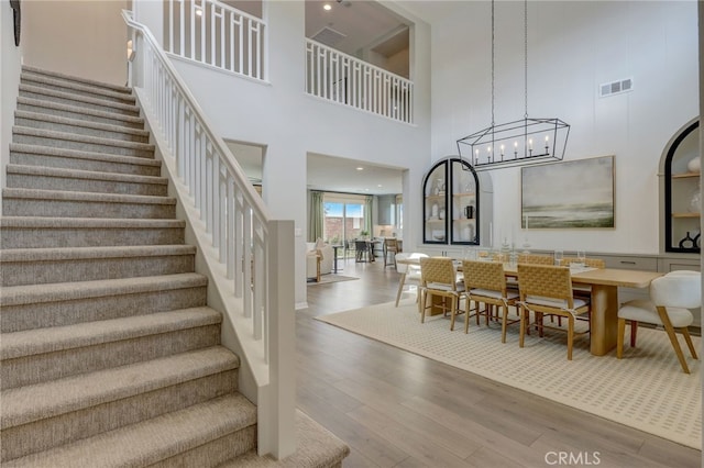 30973 Avenida Ramblas, Highland, CA 92346 - interior space featuring visible vents, a high ceiling, wood finished floors, and a chandelier
