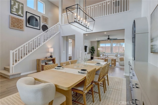 30973 Avenida Ramblas, Highland, CA 92346 - dining room with a ceiling fan, light wood-type flooring, stairway, and a towering ceiling