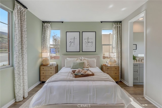 30973 Avenida Ramblas, Highland, CA 92346 - bedroom featuring baseboards, ensuite bathroom, wood finished floors, and multiple windows