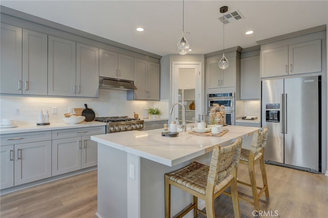 30973 Avenida Ramblas, Highland, CA 92346 - kitchen featuring under cabinet range hood, appliances with stainless steel finishes, gray cabinets, and light wood-type flooring
