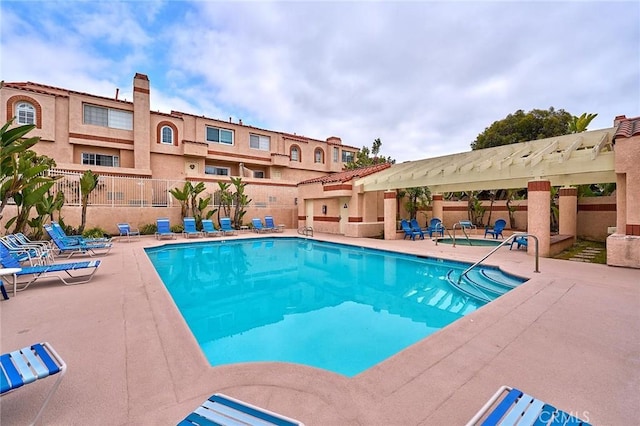 community pool featuring a patio, fence, and a pergola