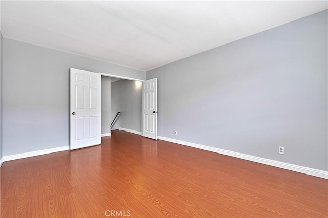unfurnished room with baseboards and wood finished floors