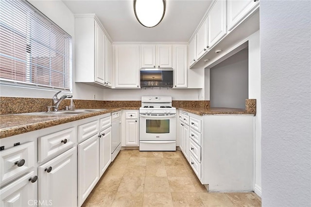 kitchen featuring white appliances, dark countertops, a sink, and white cabinets