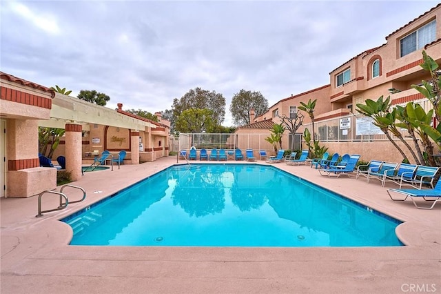 pool featuring fence and a patio area