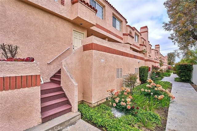 view of property with fence and stairs