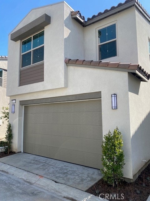 15893 Blue Copper Way, Fontana, CA 92336 - view of front of house featuring a garage, stucco siding, a tile roof, and driveway