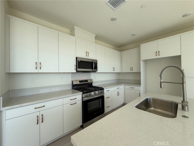 15893 Blue Copper Way, Fontana, CA 92336 - kitchen with stainless steel appliances, a sink, light countertops, white cabinetry, and recessed lighting