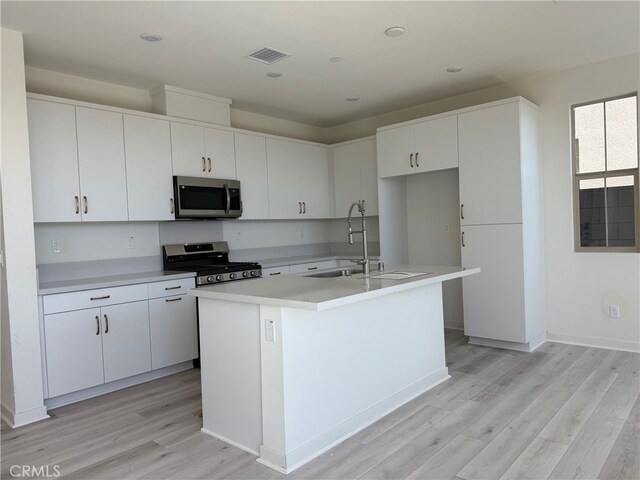15893 Blue Copper Way, Fontana, CA 92336 - kitchen with appliances with stainless steel finishes, a sink, light wood-style flooring, light countertops, and white cabinetry