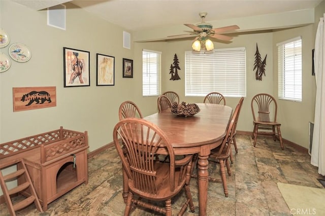 dining space with baseboards, a healthy amount of sunlight, stone finish flooring, and ceiling fan