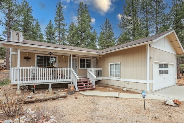view of front of house with covered porch, concrete driveway, and roof with shingles