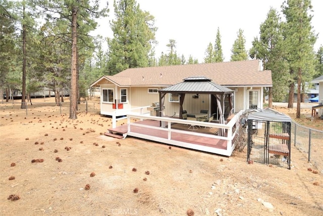 rear view of property with a gazebo, a deck, and fence