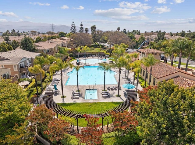 pool with a patio, fence, and a residential view