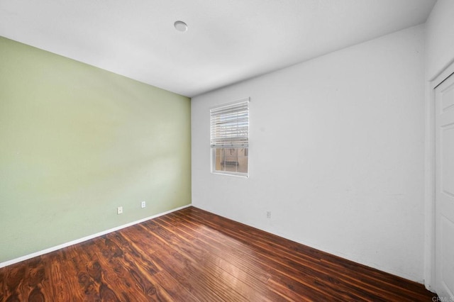 empty room with baseboards and wood finished floors