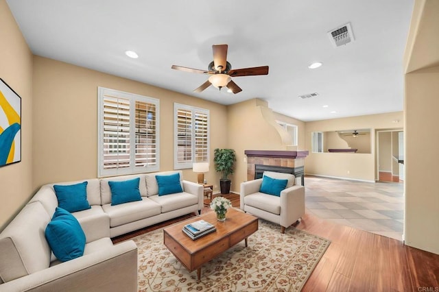 living area with a ceiling fan, visible vents, and recessed lighting