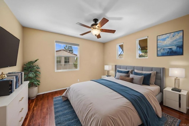 bedroom featuring baseboards, dark wood finished floors, and ceiling fan