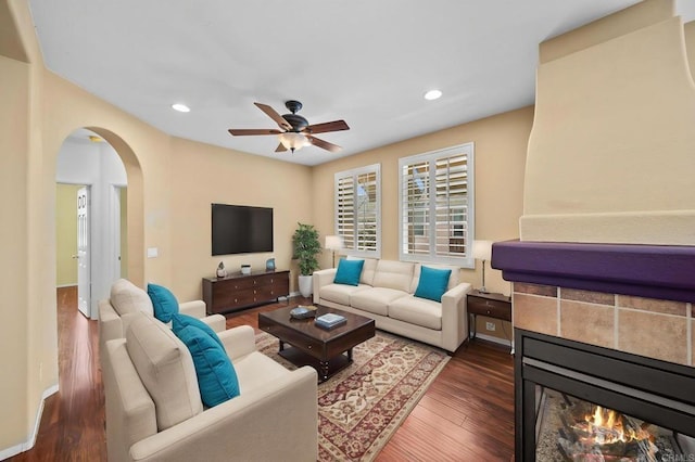 living area with recessed lighting, arched walkways, dark wood finished floors, and ceiling fan