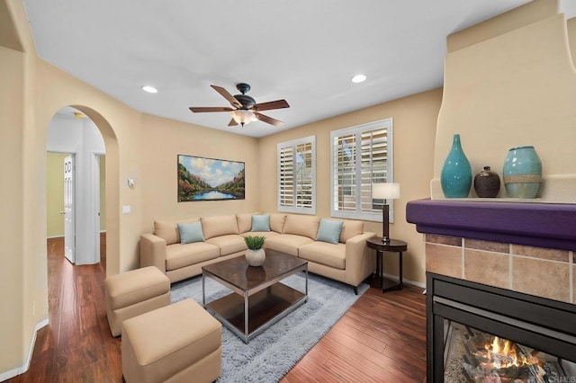 living area featuring ceiling fan, arched walkways, recessed lighting, baseboards, and wood finished floors