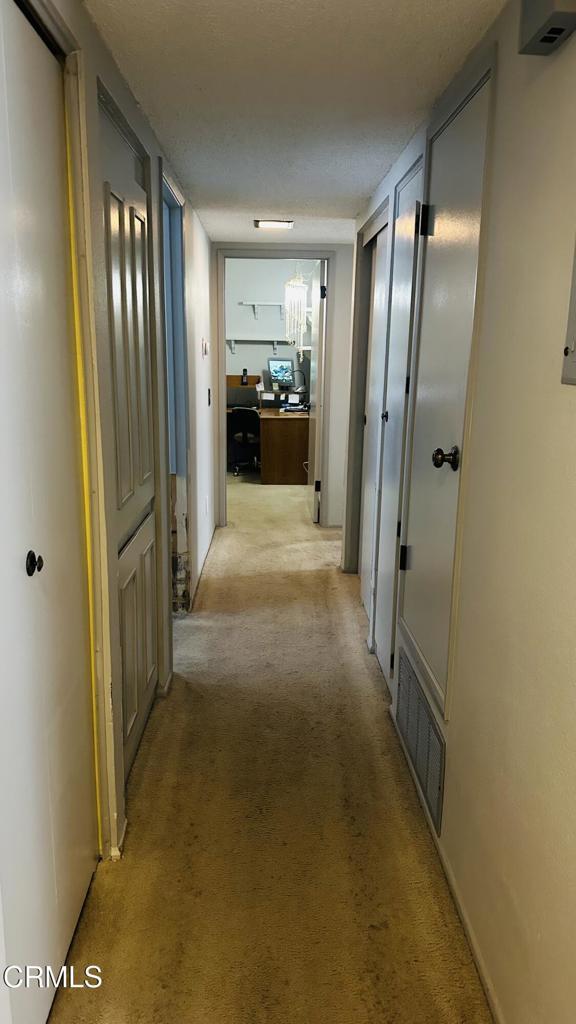 corridor with light carpet and visible vents
