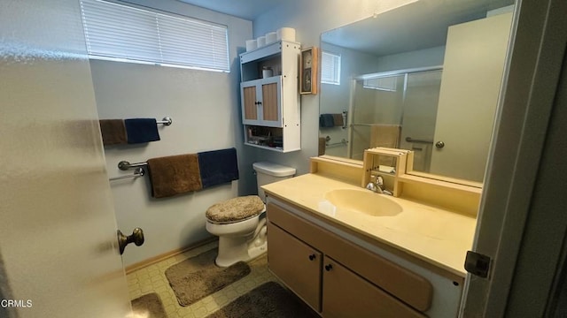 bathroom featuring vanity, a shower with shower door, and toilet