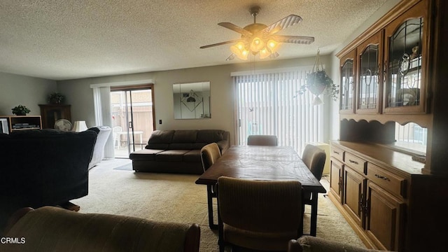 dining area with a textured ceiling, ceiling fan, and light carpet