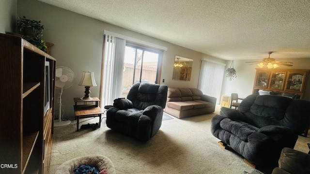 living area with a textured ceiling, carpet, and a ceiling fan