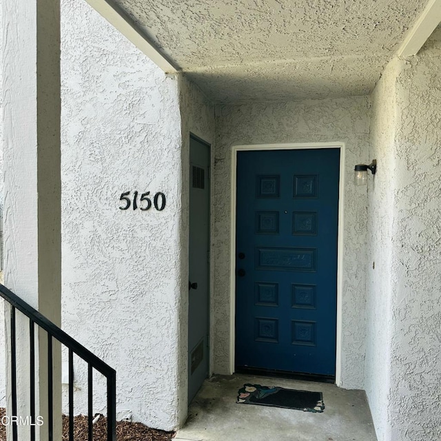 doorway to property featuring stucco siding