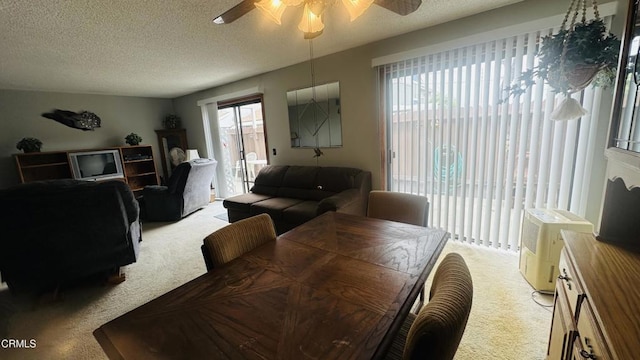 dining room with a textured ceiling, ceiling fan, and light carpet