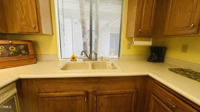 kitchen featuring a sink, light countertops, and brown cabinetry