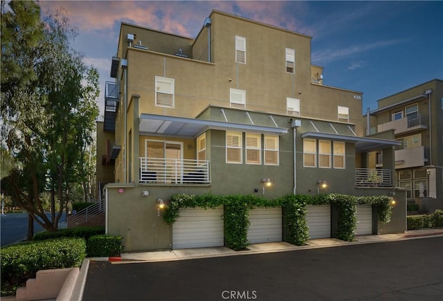 exterior space with an attached garage and stucco siding