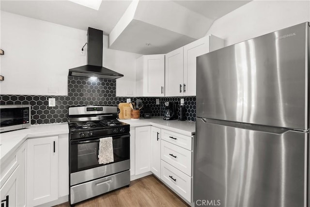 kitchen featuring light countertops, stainless steel appliances, wall chimney exhaust hood, and white cabinetry