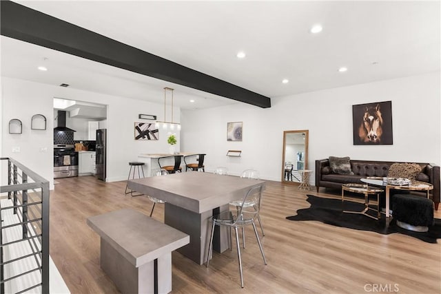 dining space with recessed lighting, light wood-style flooring, and beamed ceiling