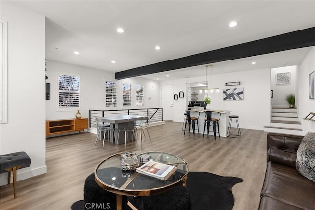 living area featuring stairway, baseboards, recessed lighting, and light wood-style flooring