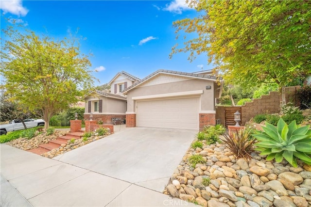 26544 Mahonia Way, Murrieta, CA 92562 - view of front of property with an attached garage, stucco siding, concrete driveway, and brick siding